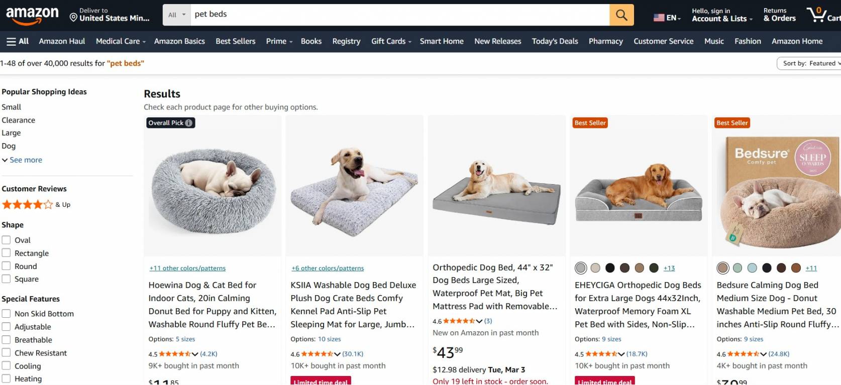 Dropshipping pet products: A screenshot of Amazon’s search results for pet beds, showing various beds with dogs lying on them, including round plush beds, a flat orthopedic bed, and a large cushioned bed. Product titles, prices, and ratings are visible.