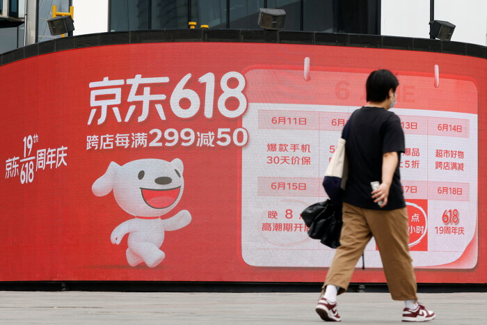 Một người đi ngang qua bảng quảng cáo của JD.com cho lễ hội mua sắm 618 năm nay. (Ảnh: Reuters).